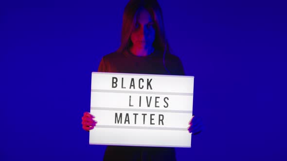 Young White Woman Hold Black Lives Matter Sign alt