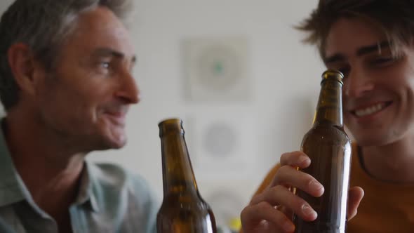 Father and young adult son socialising together alt