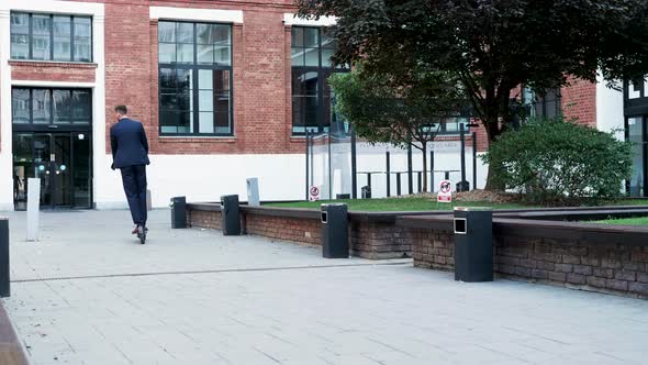 Manager in Business District Riding His Electric Scooter to or From the Work Slow Motion alt