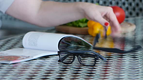 Glasses for Vision Lie on the Kitchen Table Next To Vegetables and a Magazine alt