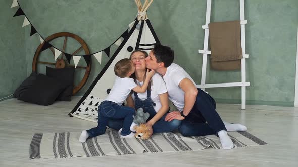 Father and Son Kissing Pregnant Mother at Home alt