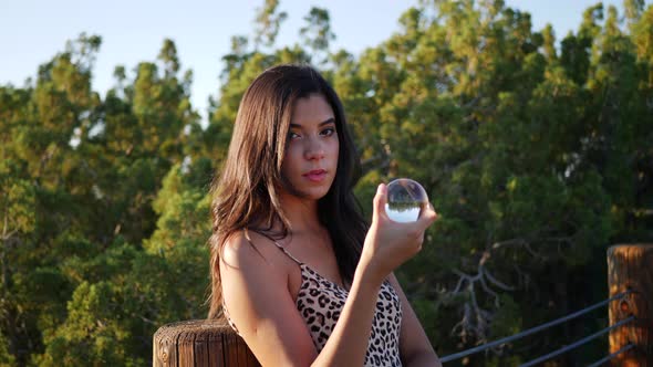 A beautiful enchanting hispanic woman in a mystical fantasy world with a magic crystal ball and a se alt