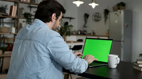 A European Young Man is Thinking Working Online Using a Laptop and Typing a Message