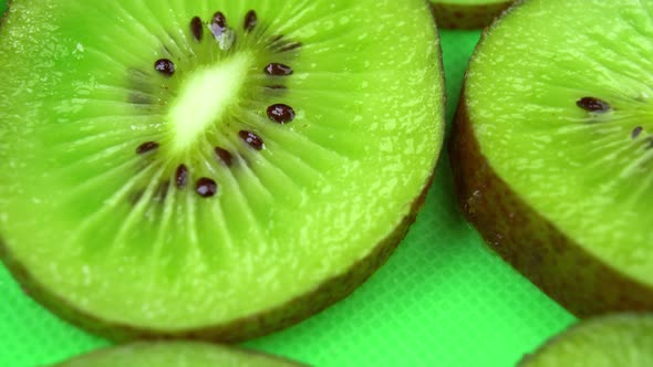 Slice of Juicy Fresh Kiwi Rotates on the Table in Close-up