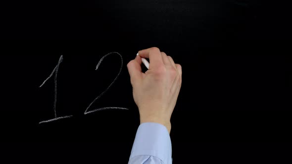 Hand writes on the blackboard with chalk one, two, three, four. Close up,
