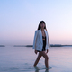 Portrait of a beautiful Middle eastern woman walking in the water wearing a jacket - PhotoDune Item for Sale