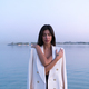 Portrait of a beautiful Middle eastern woman walking in the water wearing a jacket hugging herself - PhotoDune Item for Sale