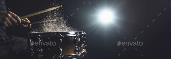 Drummer using drum sticks hitting snare drum with splashing water ...