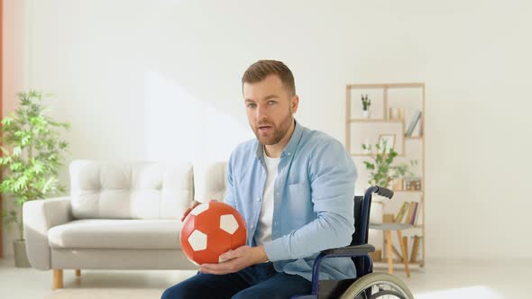 Happy Disabled Person in a Wheelchair with a Red Ball in His Hands Before a Walk alt
