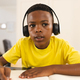 A young African American boy is focused on his homework during an online school lesson on video call - PhotoDune Item for Sale