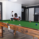 A diverse group of friends enjoys a game of pool with copy space - PhotoDune Item for Sale