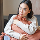 Portrait of asian woman feeling cozy in her home, hugging pillow on sofa and looking thoughtful - PhotoDune Item for Sale