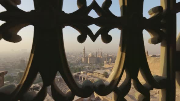 View of Cairo City and Mosque of Sultan Hassan Through Iron Bars of Window alt