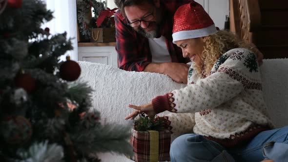 Happy woman opening Christmas gift of husband alt
