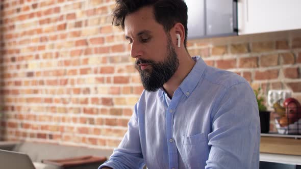 Handheld video of man working using laptop at home. Shot with RED helium camera in 8K. alt