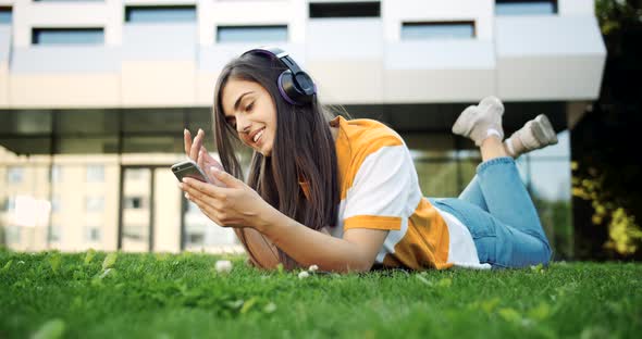 Woman Listening To Music in Headphones Outdoors