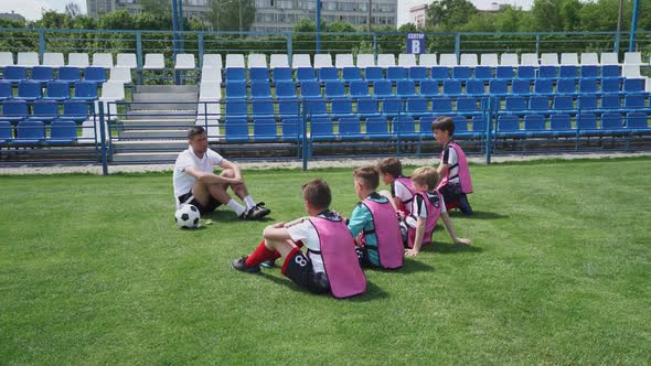 Young Team on the Training Football Field the Coach Instructs and Trains Young Players in Football alt