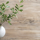 Stylish white vase holding fresh olive branches on a wooden table - PhotoDune Item for Sale