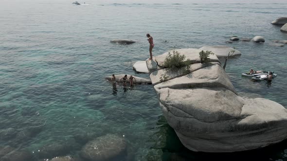 Beautiful group of young ladies jumping from the rock alt