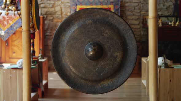 Male Hand Striking Buddhist Temple Gong for Worship 