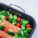 Raw salmon fillet with broccoli and tomato on frying tray, ready to bake, vertical, copy space - PhotoDune Item for Sale
