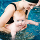 Young mother, swimming instructor and happy little girl in paddling pool. Teaches infant child to sw - PhotoDune Item for Sale