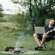 Young freelancer relaxing in forest. Man working on laptop on nature. Remote work, outdoor activity  - PhotoDune Item for Sale