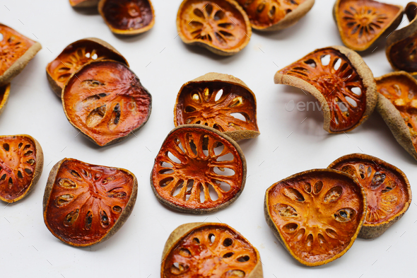 Dried bael fruit slices on white background. Stock Photo by bowonpats