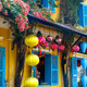 Traditional yellow house with blue shutters and colorful lanterns - PhotoDune Item for Sale