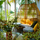 Cozy sunlit balcony with a bohemian rattan egg chair and vibrant yellow cushions - PhotoDune Item for Sale