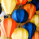 Close-up of colorful hot air balloon lanterns hanging against a yellow wall - PhotoDune Item for Sale