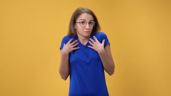 Portrait of Doubtful Woman Don't Know Puzzlement Face Expression Posing Isolated on Orange Studio alt