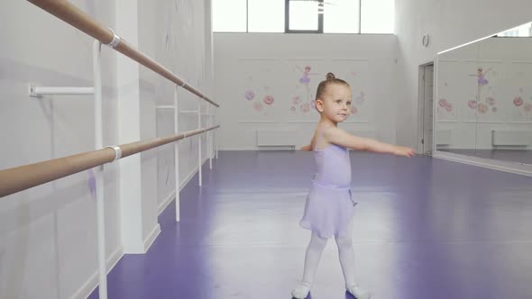Cute Little Ballerina in Leotard Whirling in Dance at Ballet School