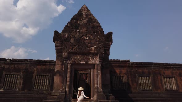 Woman in vietnamese hat go up the stairs to palace, Wat Phou Hindu Temple, ancient architecture Laos alt