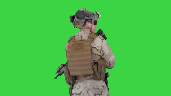 Fully Equipped Solder Holding Assault Rifle and Standing Looking To the Sides on a Green Screen alt