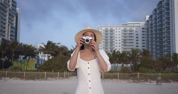 Smiling woman with a retro camera in Miami. Shot on Black Magic Cinema Camera alt