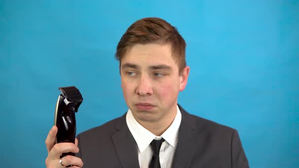 Businessman with a Hairdresser. A Man in a Suit on a Blue Background Is Preparing for a Haircut. alt