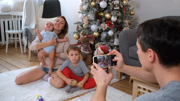 Father Photographing Family By Phone at Christmas alt