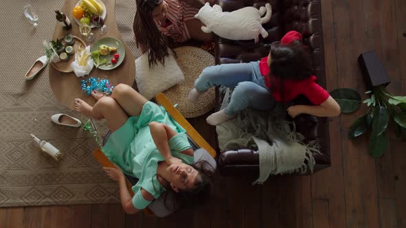 Top View of Mixed Race Women Suffering Symptoms of Hangover at Home alt