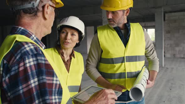 Three caucasian engineers discussing on construction site. Shot with RED helium camera in 8K alt
