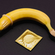 Banana with Condom on black background. Sexual Health and Education Concept - PhotoDune Item for Sale
