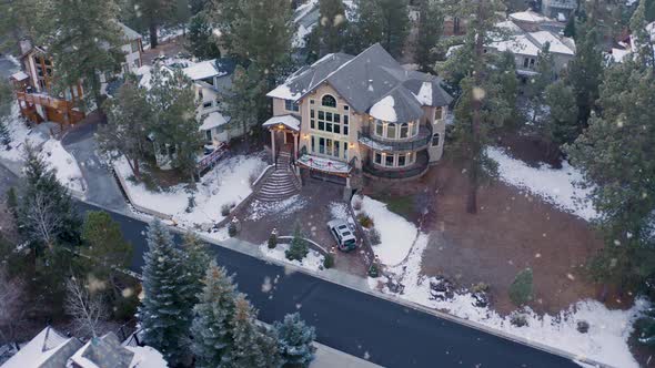 Luxurious large mansion with stunning exterior design and tall pines at snowfall alt