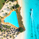 Aerial view of pool, sandy beach, palms, umbrellas, boat, sea - PhotoDune Item for Sale