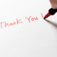 Hand written thank you message with a red pen on white background, gratitude concept. - PhotoDune Item for Sale