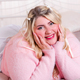 Happy curvy woman in sweater lying on bed - PhotoDune Item for Sale
