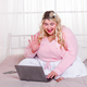 Smiling plus size woman having video chat with laptop - PhotoDune Item for Sale