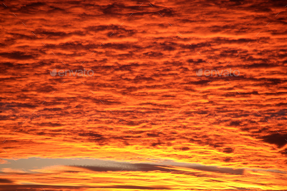 Bright colorful sunset sky with vivid smooth clouds illuminated with setting sun - Stock Photo - Images