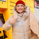 Happy smiling woman client with box at outdoor automated parcel machine choosing operation on touch - PhotoDune Item for Sale