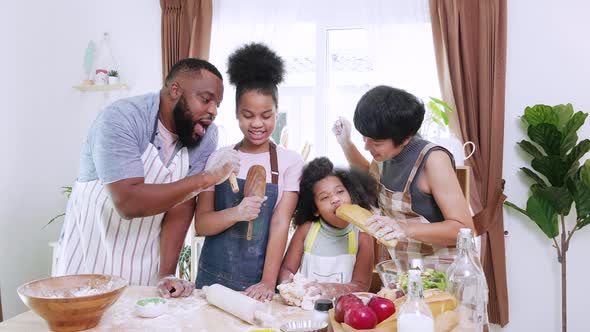 African American family with little adorable daughters singing and dancing together in kitchen