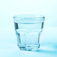 Glass of water on blue background. - PhotoDune Item for Sale